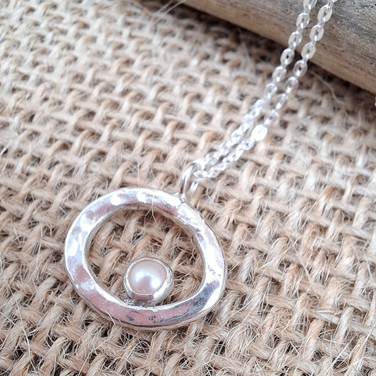 Hammered silver pebble shaped pendant set with a freshwater pearl