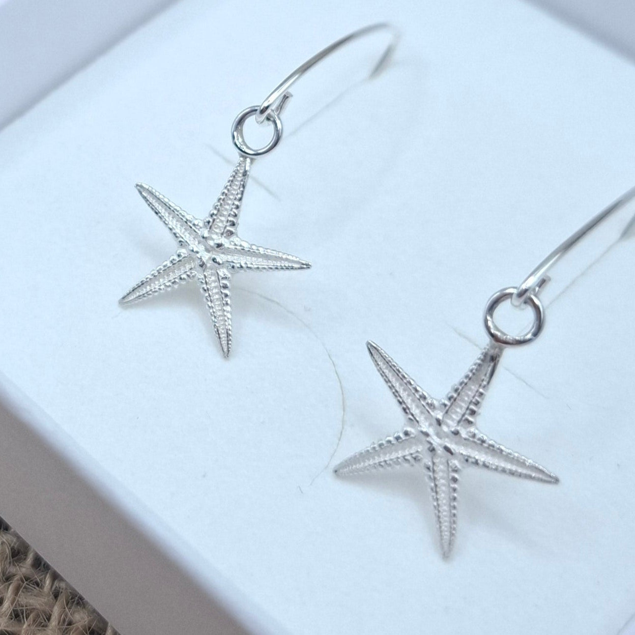 Cast silver starfish dangly earrings on a V shaped ear wire