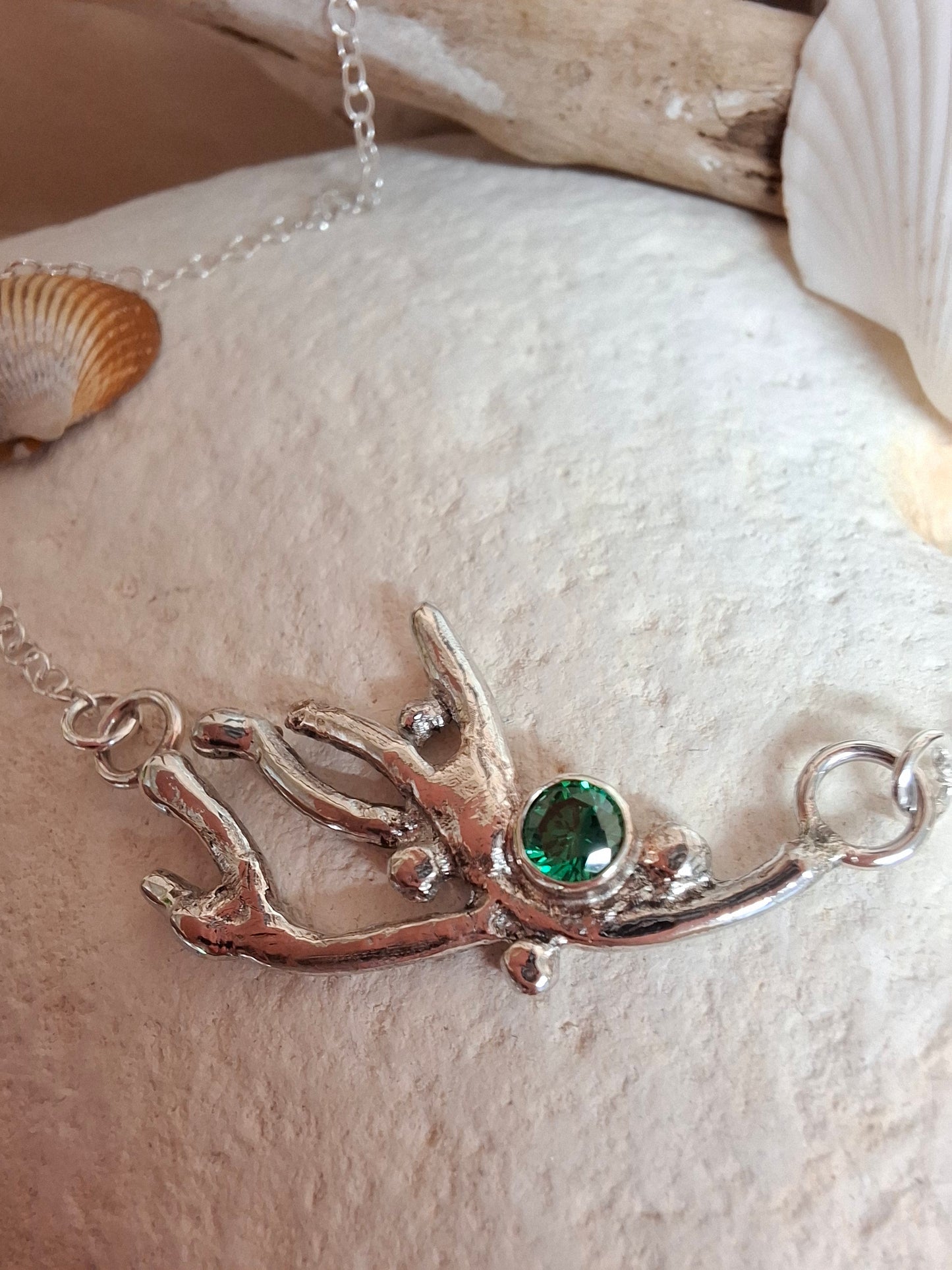 Silver coral branch inspired necklace with a green cubic zirconia