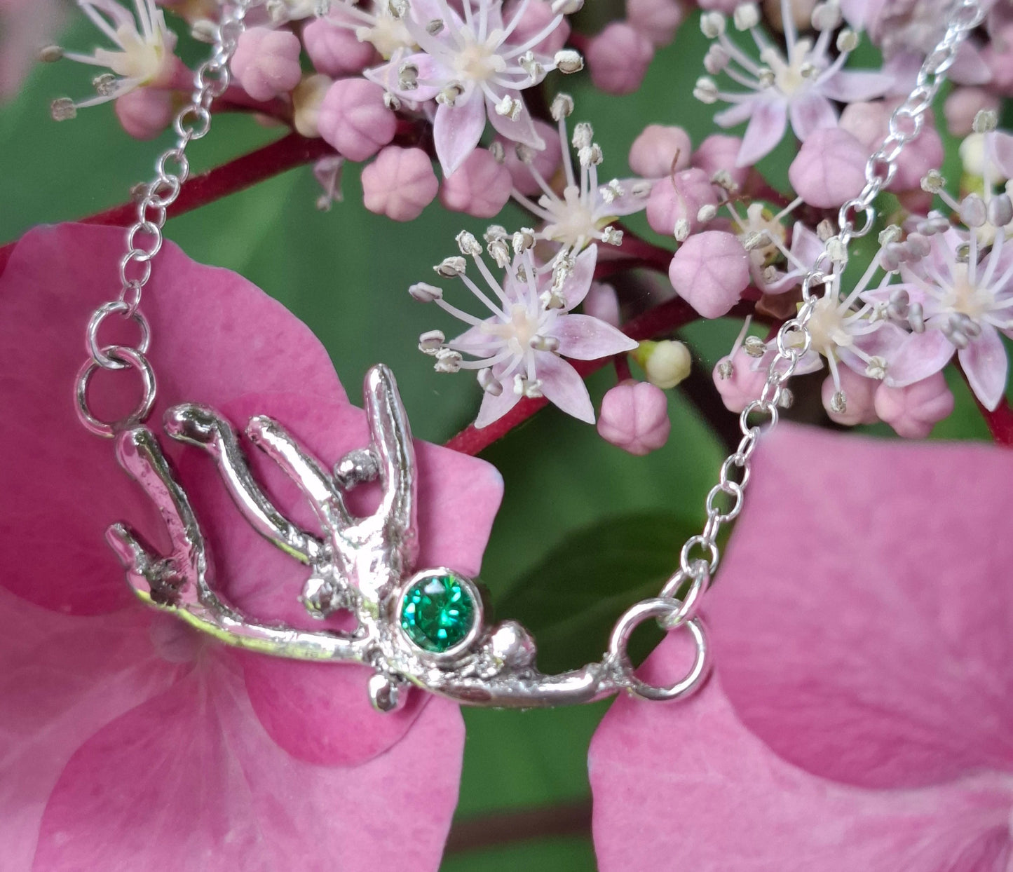 Silver coral branch inspired necklace with a green cubic zirconia