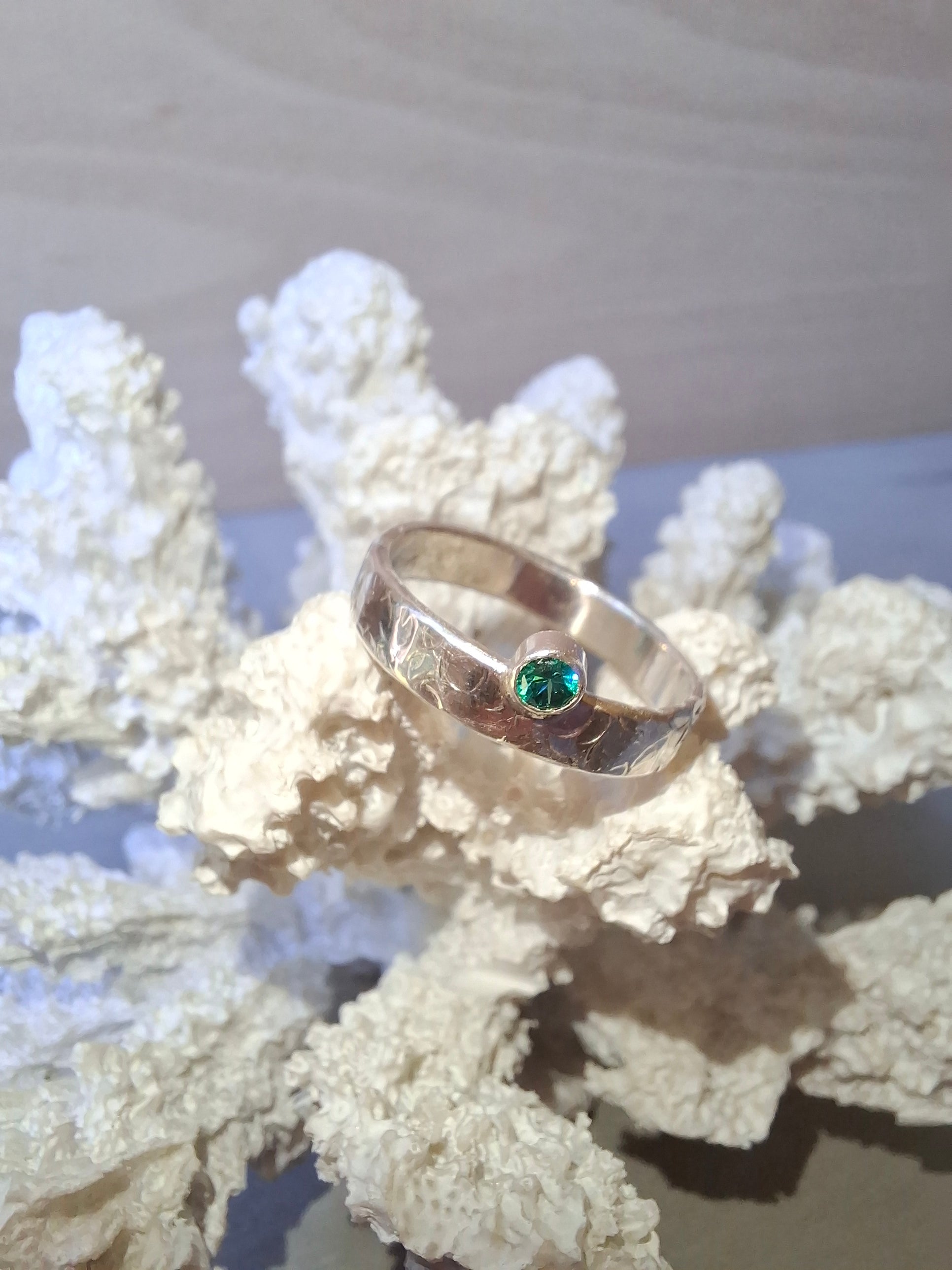 Hammered textured silver ring with teal cubic zirconia.