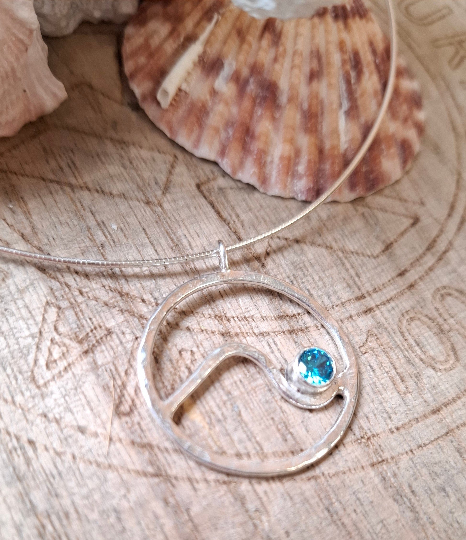 Hammered circle wave pendant with aquamarine cubic zirconia