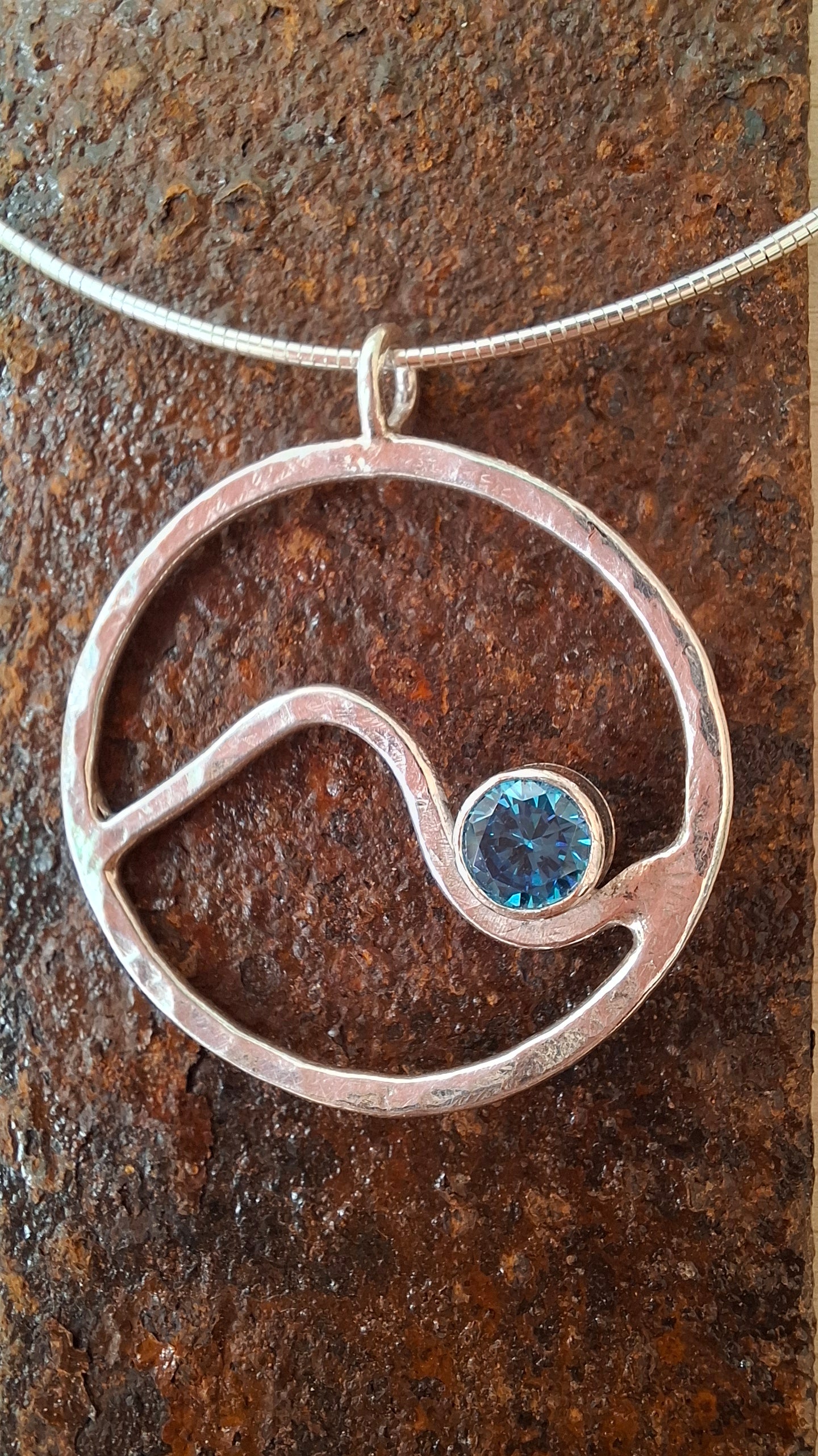 Hammered circle wave pendant with aquamarine cubic zirconia