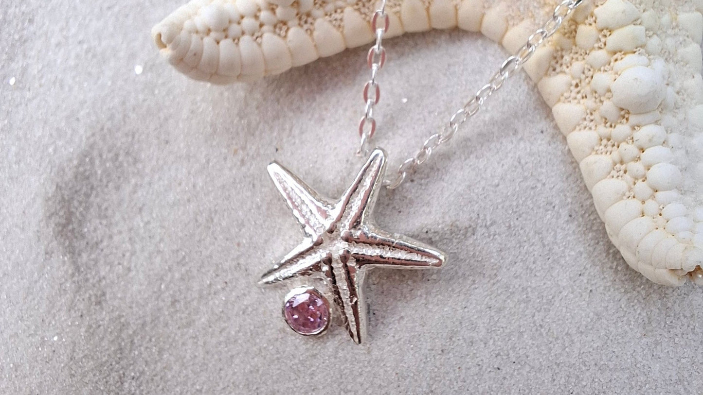 Cast silver starfish pendant with a vibrant cubic zirconia