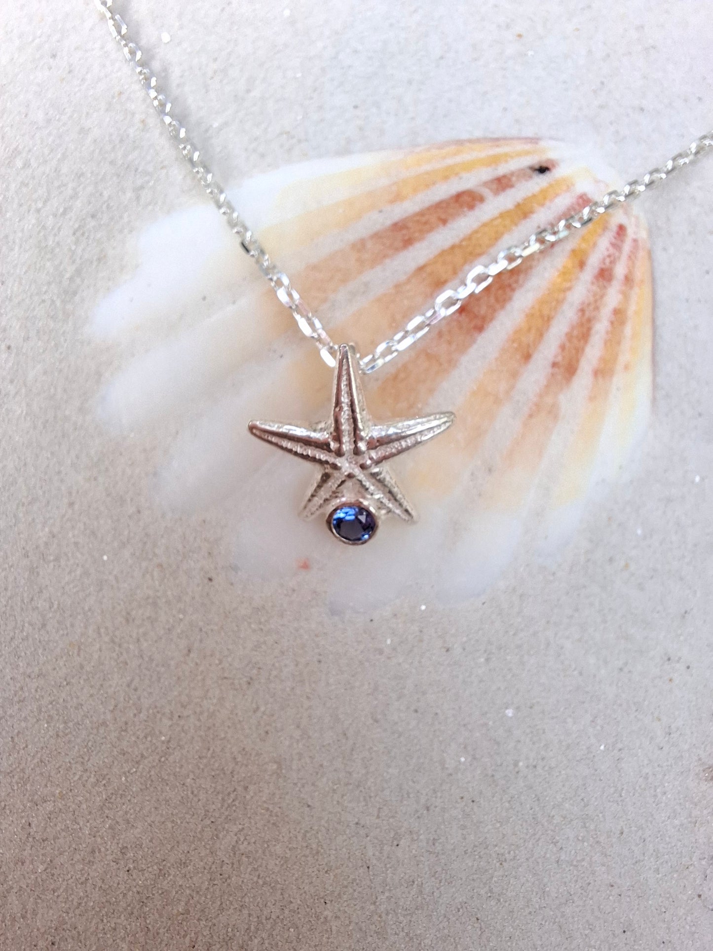 Cast silver starfish pendant with a vibrant cubic zirconia