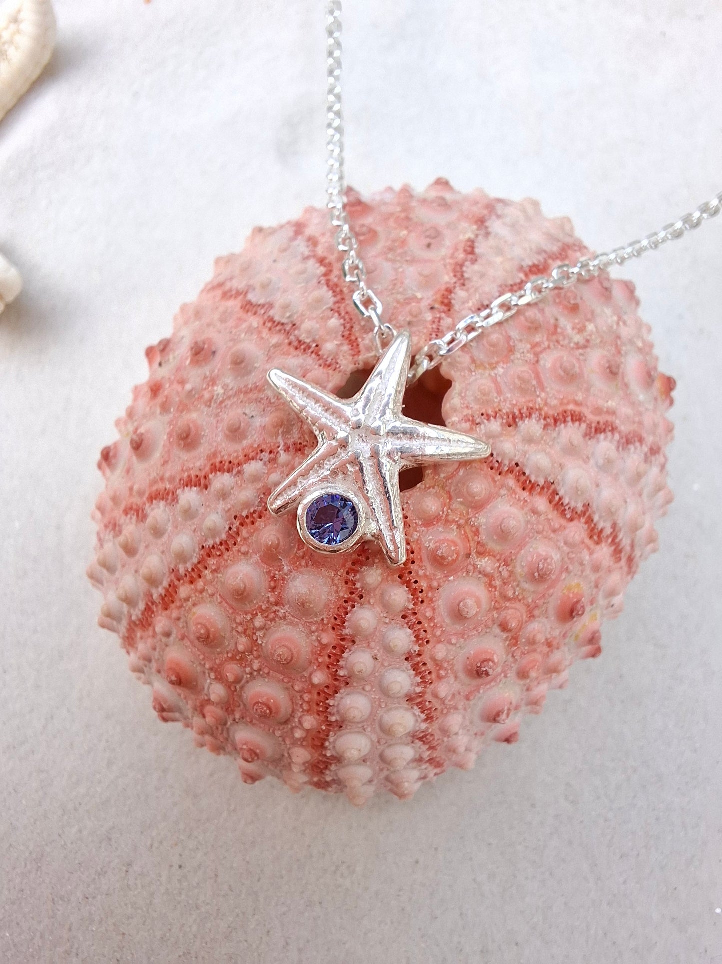 Cast silver starfish pendant with a vibrant cubic zirconia