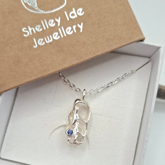 Cast silver seashell pendant with a tanzanite cubic zirconia | Ocean-Inspired Handmade Jewellery - Shelley Ide Jewellery
