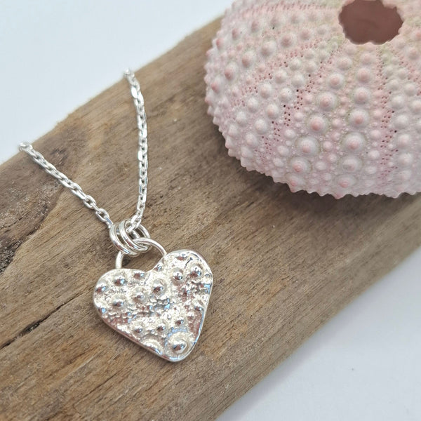 Cast silver sea urchin heart pendant from Shelley Ide Jewellery, featuring intricate sea urchin texture and a delicate necklace chain.