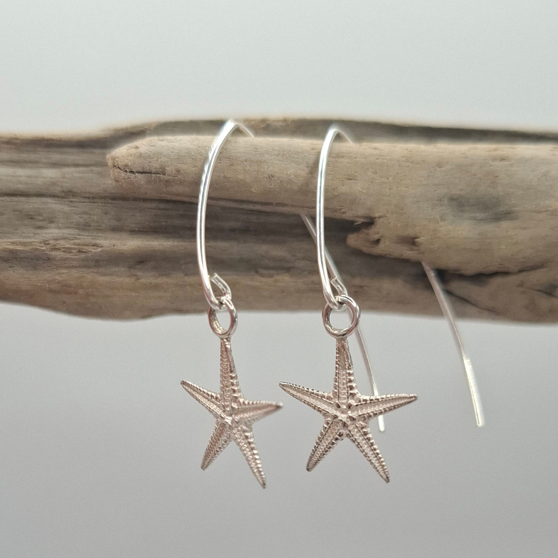 Cast silver starfish dangly earrings on a V shaped ear wire | Ocean-Inspired Handmade Jewellery