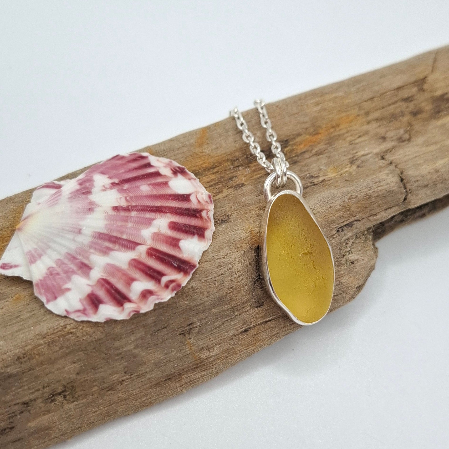 Large Channel Islands rare yellow seaglass pendant on a necklace, showcasing its smooth, natural glass shape and vibrant color.