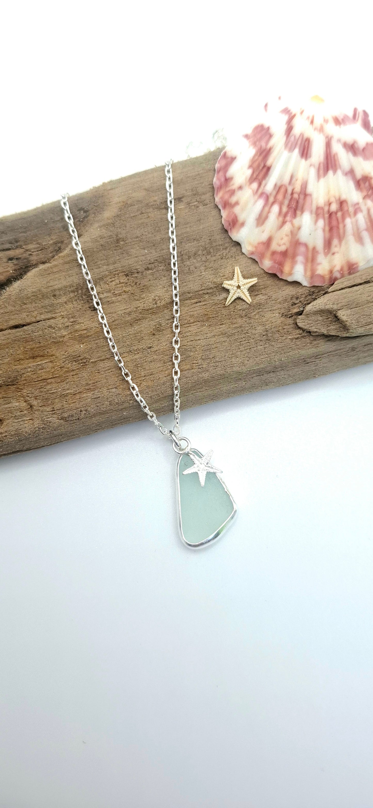 Silver necklace with a star pendant on a white background