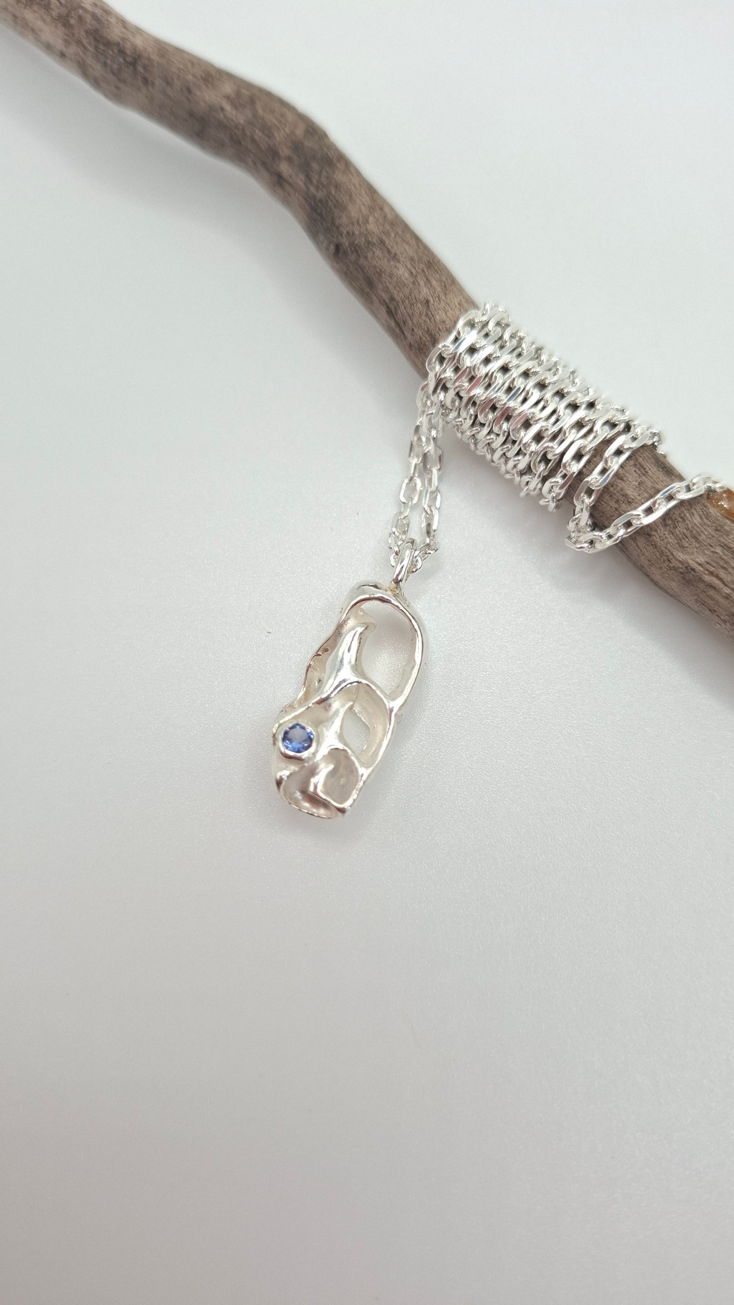 Cast silver seashell pendant with a tanzanite 